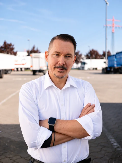 Gründer Tobias Stancke im weißen Hemd auf einem Lkw-Hof